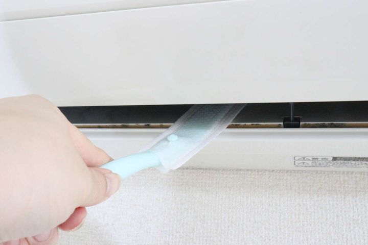 エアコンの吹き出し口にワイパーを差し込み掃除を始める様子