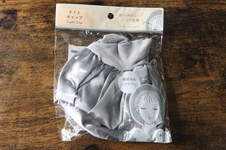 セリアのナイトキャップが透明な袋に入り木目調の台に置かれている