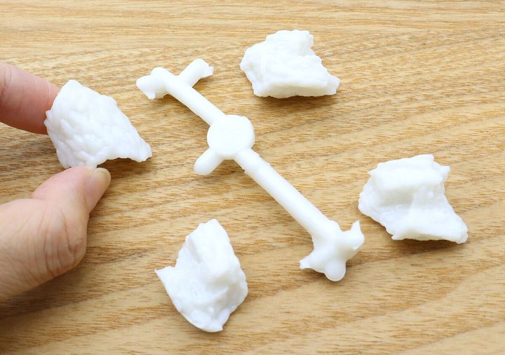 指でシャリのパズルパーツを組み立てようとしている様子。複数のシャリパーツが散らばる