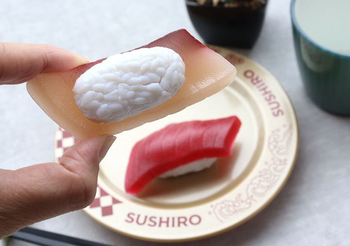 指で持ったはまちの寿司パズルと、奥の皿に乗ったまぐろの寿司パズルを一緒に撮影