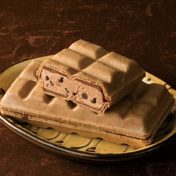 茶色い皿に置かれた割れたチョコアイスモナカと下のモナカ