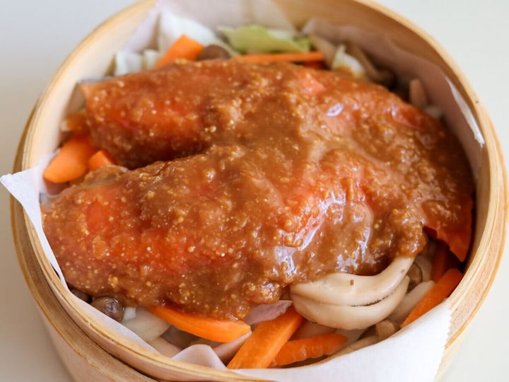 せいろに敷かれた野菜の上に、味噌だれがかけられた2切れの生鮭が乗せられている