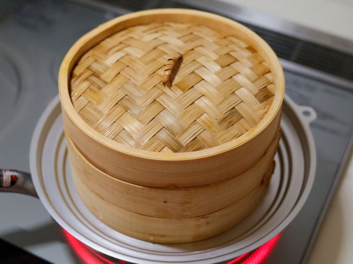 IHクッキングヒーターの上に置かれた鍋にせいろがセットされ、蓋がされている状態。蒸気で鍋の縁が赤く光っている