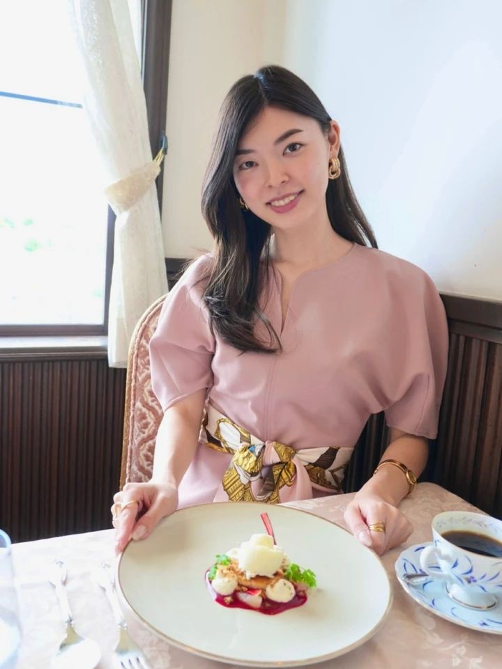 ピンクのペプラムトップスにスカーフを巻いた上半身の着こなし