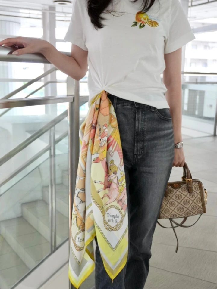 白Tシャツにイエロー系スカーフを結び、デニムとスニーカーを合わせたカジュアルコーデ