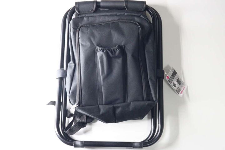 黒い折りたたみイスとリュックが一体化した商品が上から写っている