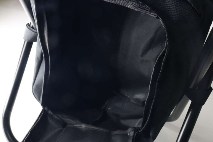 リュックのメイン収納部分のファスナーを開けて中が空であることを示している