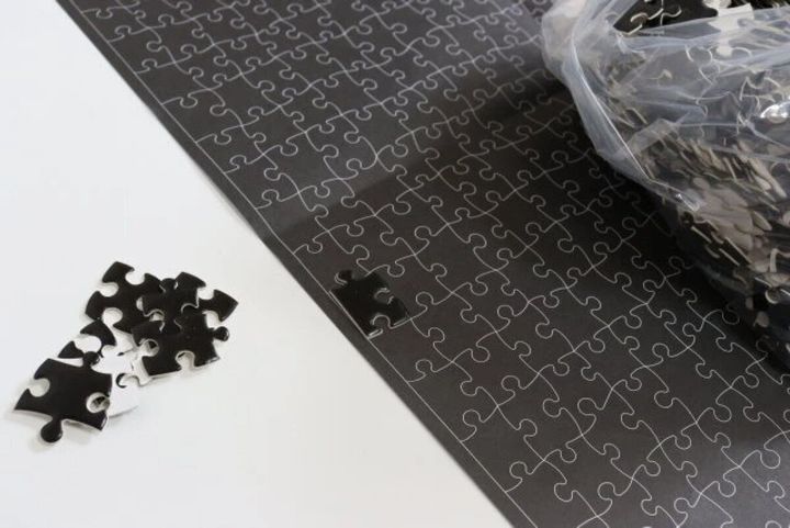 黒いパズルの参照紙と、その上に置かれた数個の黒いピース