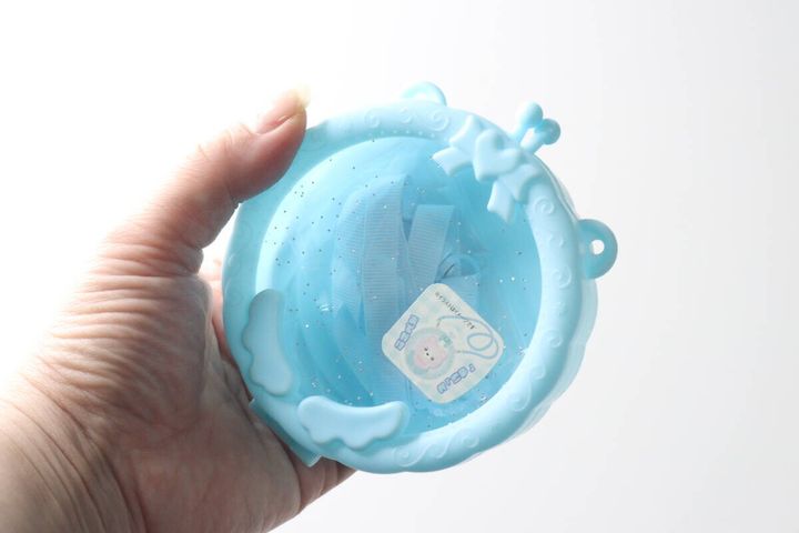女性が水色のサークルポシェットを手に持っている様子。
