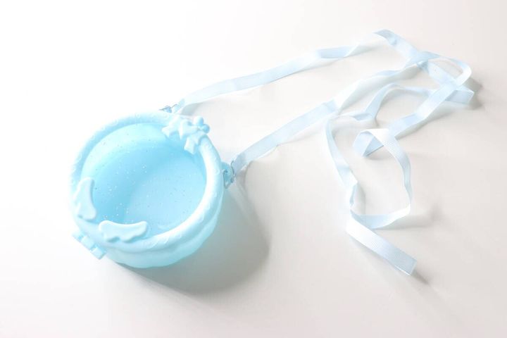 水色のサークルポシェットと付属の白いストラップが並べられている。