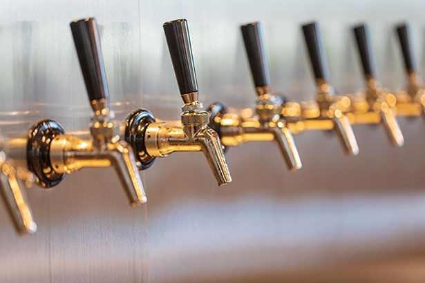 カウンター奥の壁に15口のタップが整然と並ぶ／CRAFT-BEER-STAND-ゆい