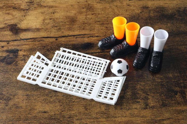 フィンガーサッカーのパーツが木目テーブルに並ぶ