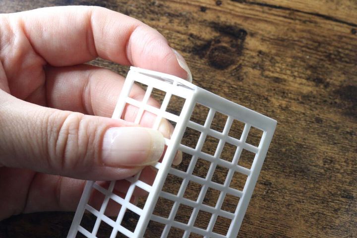 白いゴールネットを組み立てている指先のアップ
