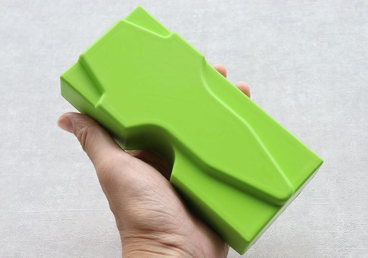 手のひらに乗せた鮮やかな緑色の仙骨枕