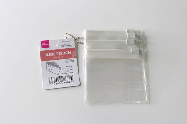 ダイソーのスライドポーチ4枚セットと商品タグが白い背景に置かれている