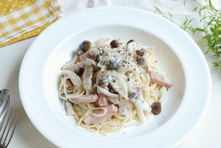 白い深皿に盛られた濃厚きのこクリームパスタ。黒胡椒がたっぷりかかっている。