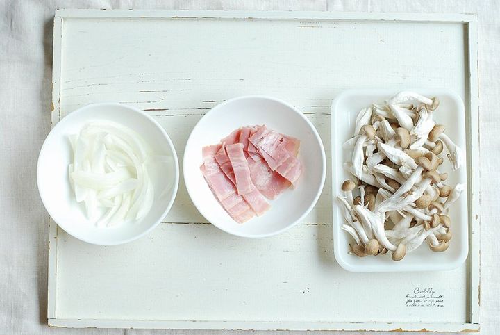 薄切り玉ねぎ、カットしたベーコン、ほぐしたしめじが白い器に盛られている。