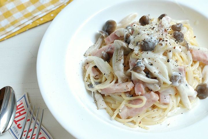 白い深皿に盛り付けられた濃厚きのこクリームパスタのアップ。黒胡椒がたっぷり。