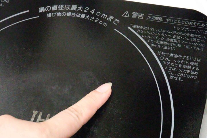 きれいになったIHコンロの天板を指で指して確認している