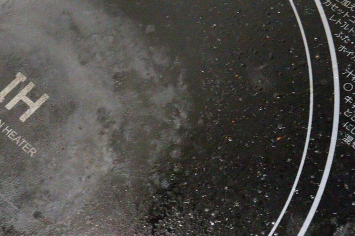 広範囲に油汚れが飛び散ったIHコンロの黒い天板