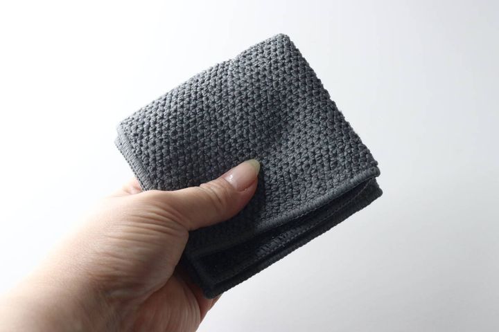 女性の手のひらに乗せられたグレーのマイクロファイバークロス