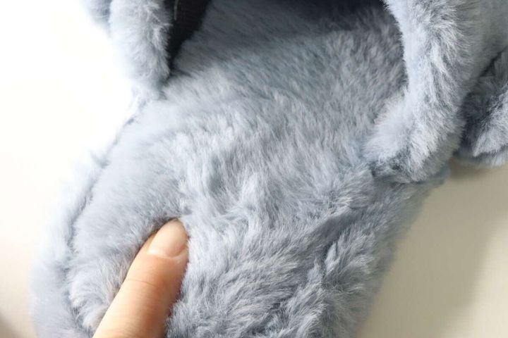 指でライトブルーのサメ型スリッパのファー部分を押している