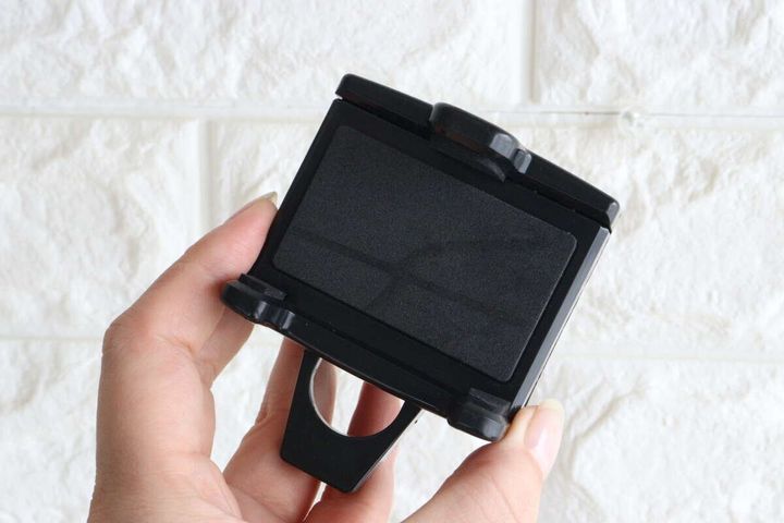 女性の手が黒いスマホホルダー本体を横から持っている