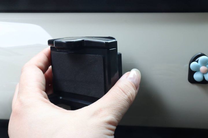 女性の手がスマホホルダーを取り付けている