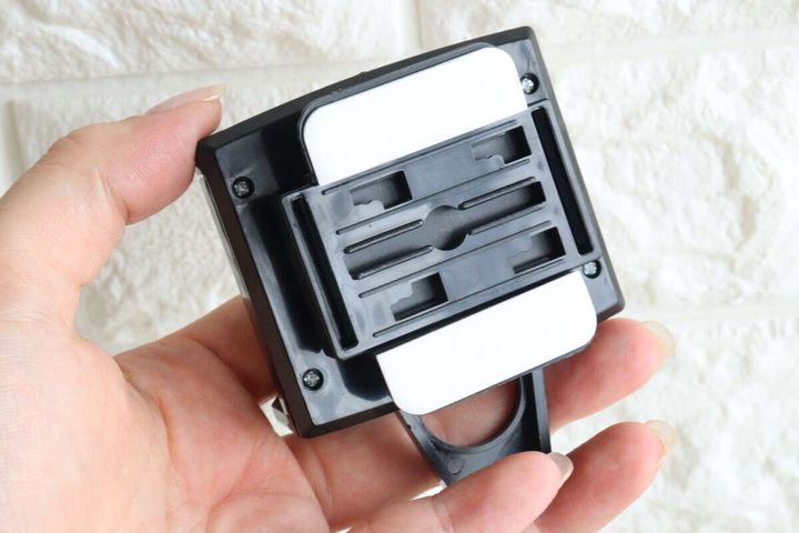 女性の手がスマホホルダー裏側のクリップ差し込み口を見せている