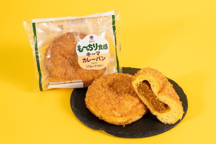 黄色い背景にキーマカレーパンと半分に割られた断面