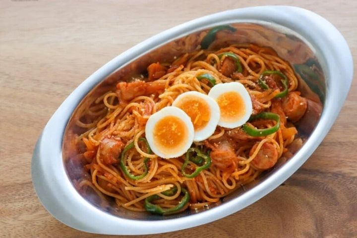 ゆで卵がトッピングされたウインナーとピーマンのナポリタン