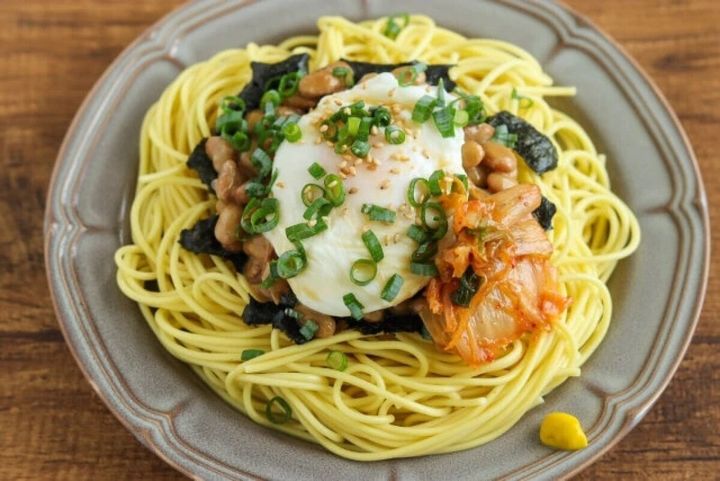 キムチがトッピングされたポーチドエッグと納豆の和風パスタ