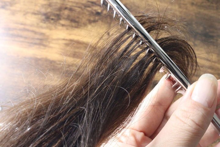 絡まった女性の髪をスムースコームで優しくほぐしている様子
