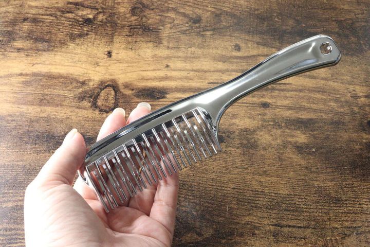 女性の手のひらに乗せられたメタリックなスムースコーム