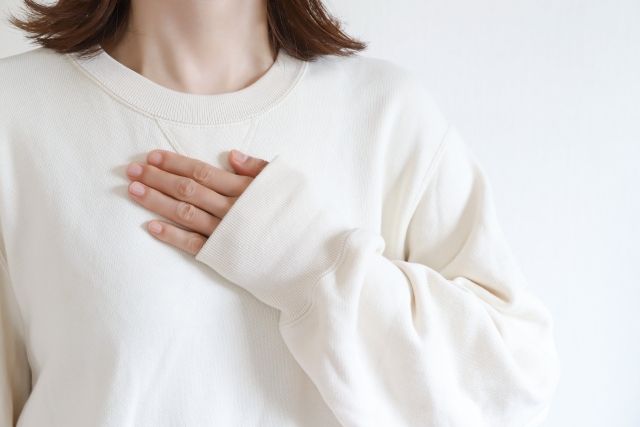 胸に手を当てる女性