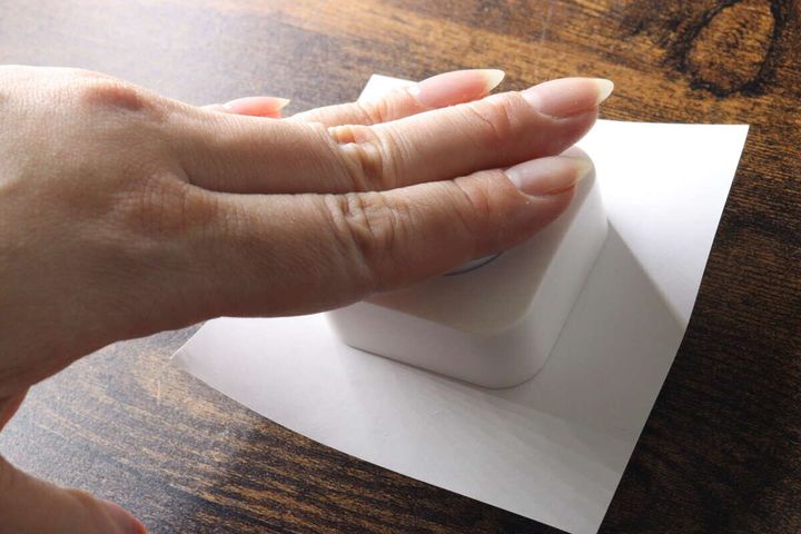クラフトパンチの上部を手のひらで上から押して型抜きしている様子