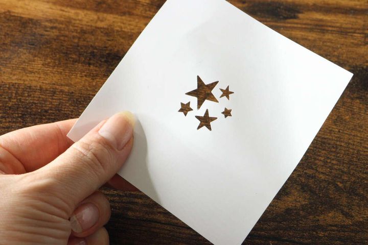 星型の穴が複数開いた白い紙を指で持っている様子