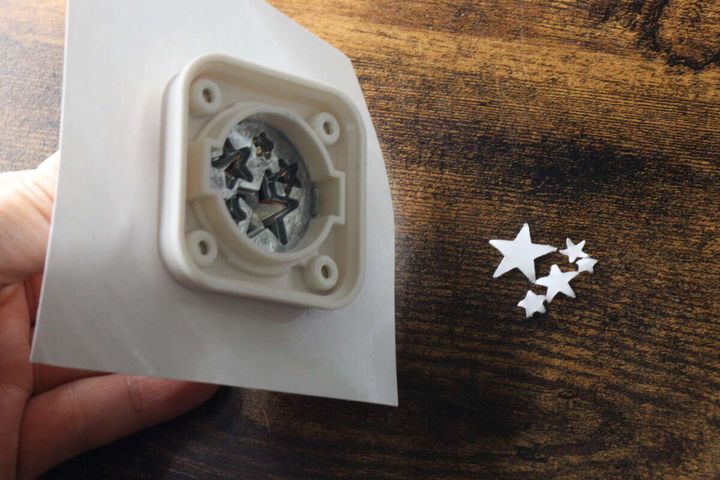 型抜きされた白い紙と、パンチで切り抜かれた大小の星型の紙片