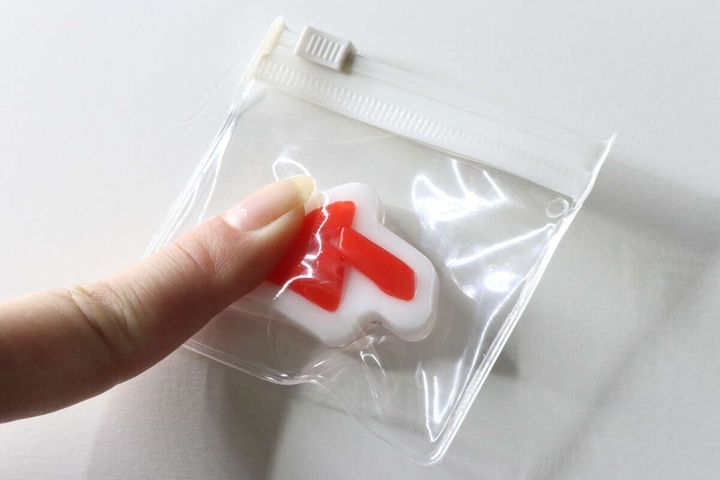 透明ポーチに入ったムーロゴスクイーズを指で押して感触を確かめている