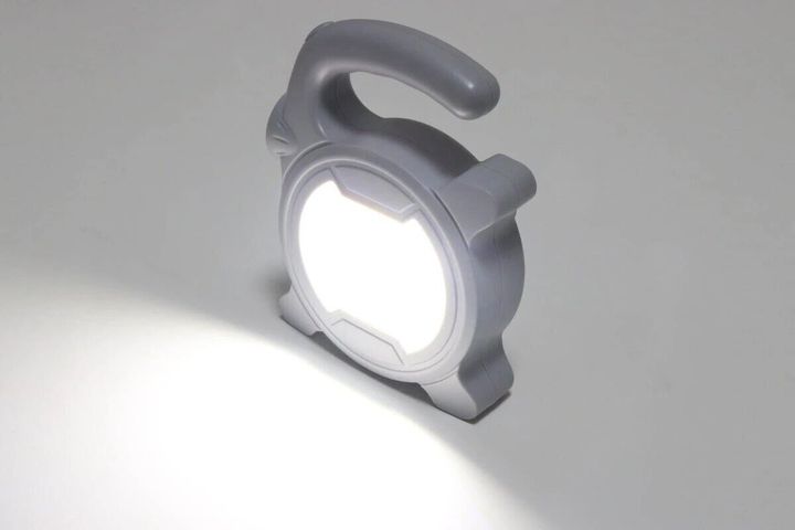 グレーの手持ちライトが白い光を放ち床を照らしている