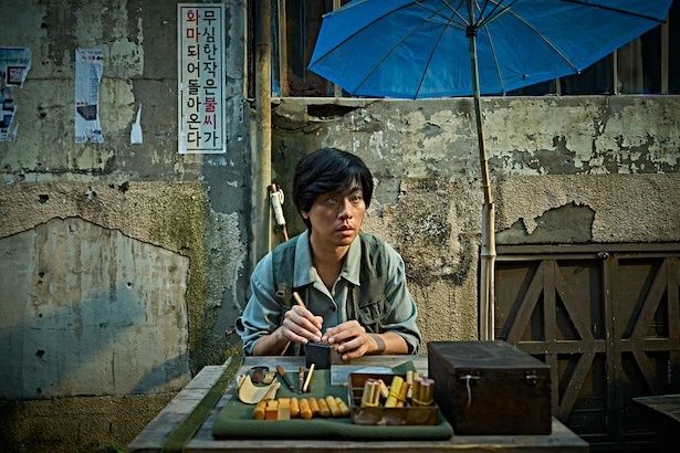 判子を彫って生計を立てる若き日のイム・ヨンギュ(パク・ジョンミン) (C)2025 WOWPOINT, ALL RIGHTS RESERVED.