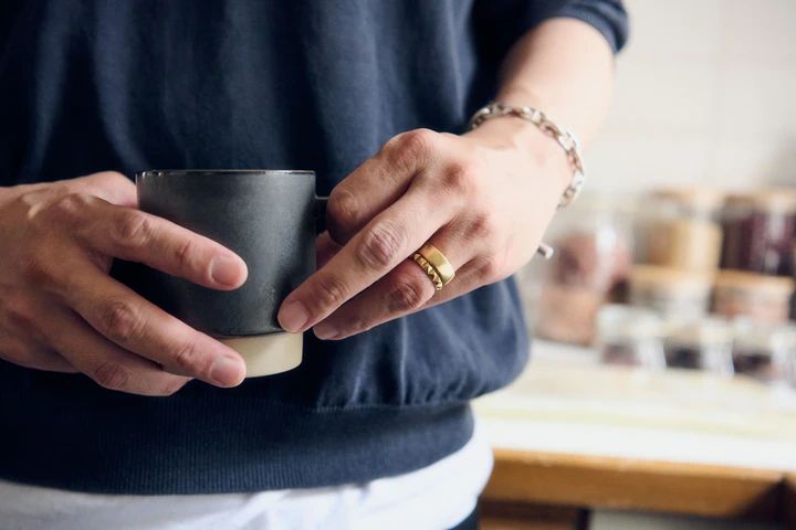 スタイリスト池田敬さんがオーダーで作った「CADEAUX」の結婚指輪をつけている様子
