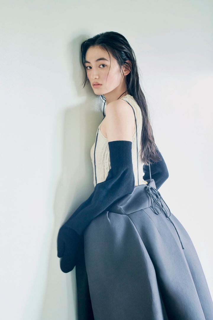 黒の立体的なワンピースに黒のロンググローブを合わせた八木莉可子