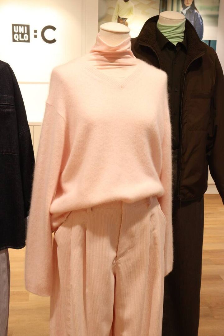 ピンクのタートルネックとVネックニットを重ね着したマネキン