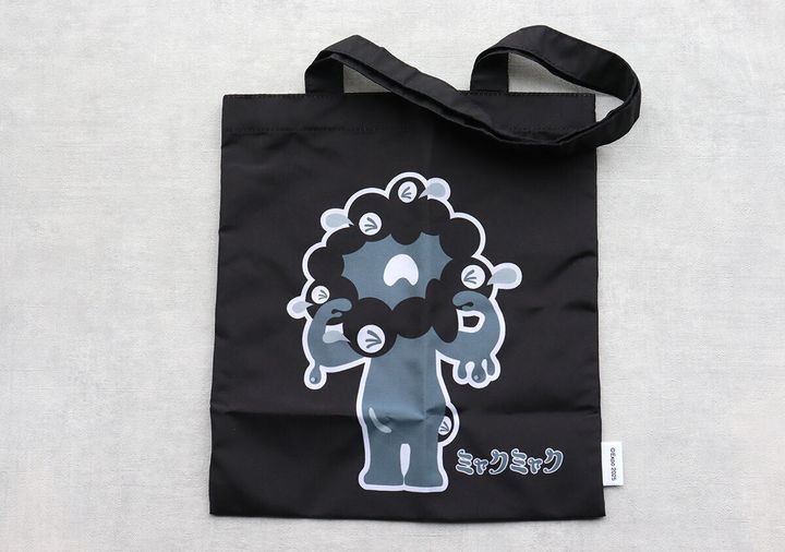 黒の中サイズミャクミャクトートバッグが広げられている