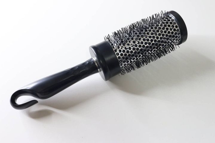 白い背景に置かれた黒いロールヘアブラシ本体