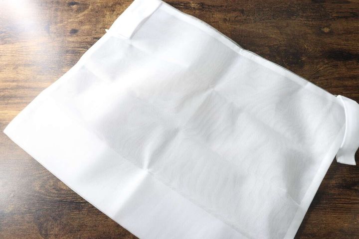木目のテーブルに広げられた白い洗濯ネットの全体像