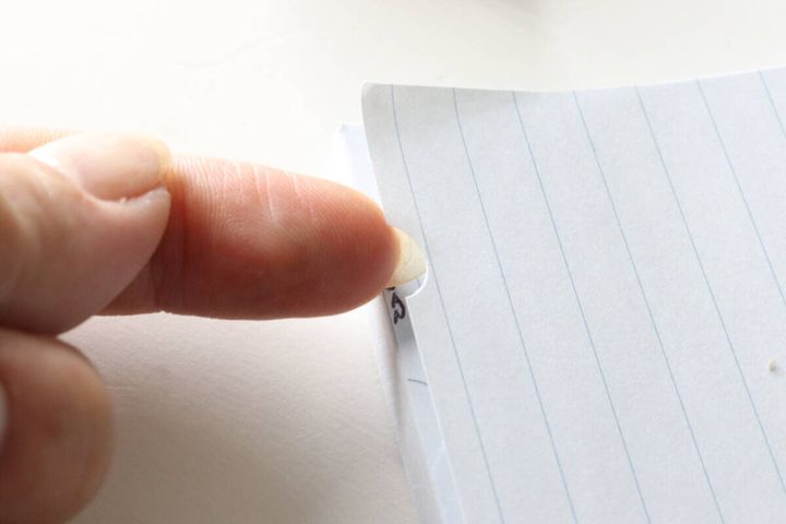 半円形にカットされたインデックス部分を指でめくっている様子