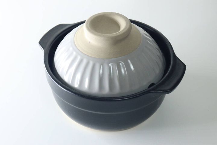グレーの蓋が乗った黒いコンパクトな土鍋