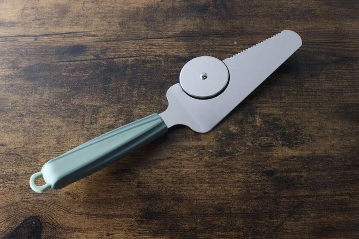 緑色の持ち手が付いた、ピザサーバーとピザカッターが一体化した商品。